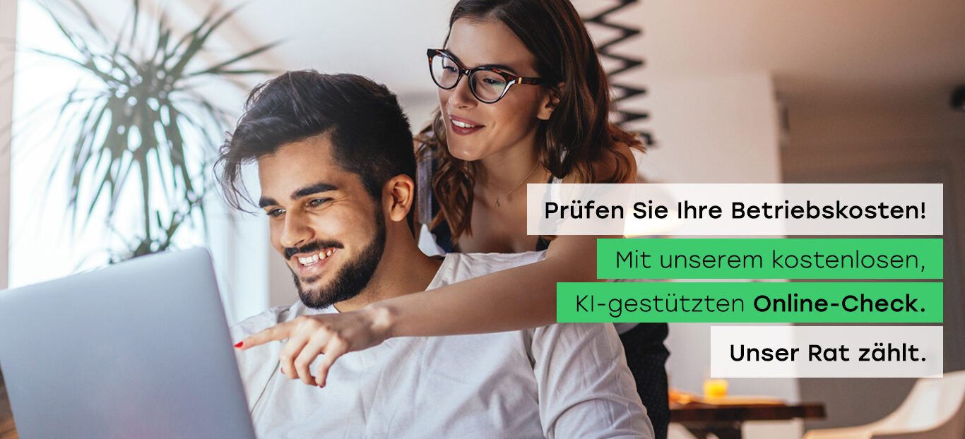 Ein Mann und eine Frau sitzen zusammen und blicken auf einen Laptop, der auf einem Tisch vor ihnen steht.