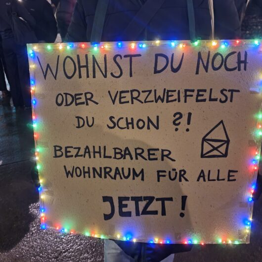 Protestschild mit der Aufschrift: Wohnst du noch oder verzweifelst du schon. Bezahlbarer Wohnraum für alle. Jetzt!