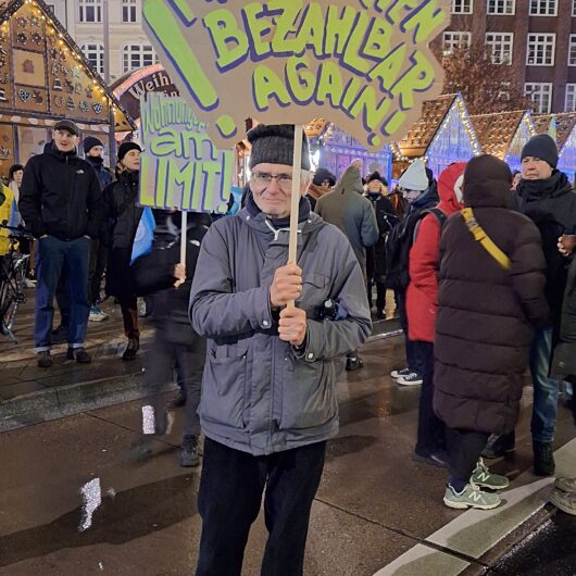 Ein Protestant hält ein Protestschild in der Hand auf dem Make Mieten bezahlbar again steht