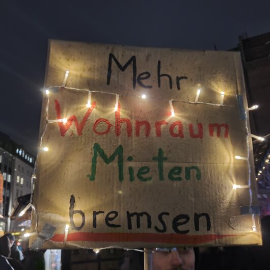 Ein Protestschild auf dem Mehr Wohnraum, Mieten bremsen steht.